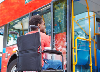 Man In Wheelchair Boarding Bus By Himself Struggling