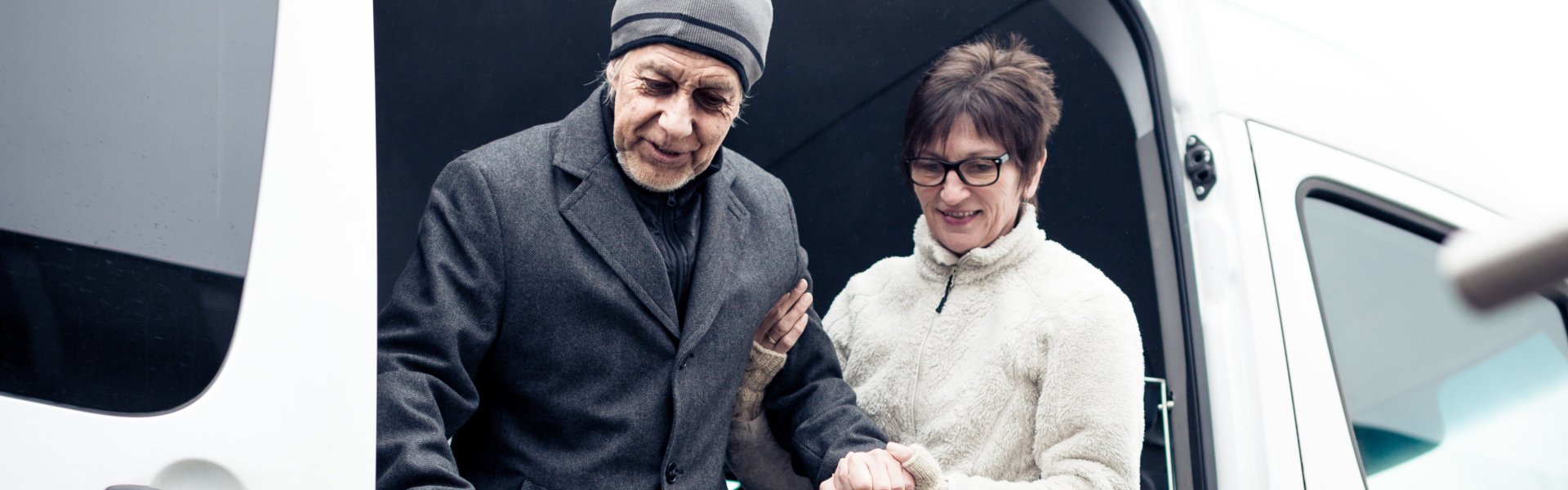 Nurse Helping Senior Man Exit A Van